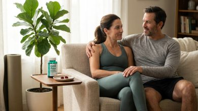 Couple relaxing at home after exercise, wondering how long does post workout bloating last, Goli bottle nearby
