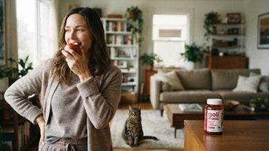Woman eating a fresh apple at home, where Goli Apple Cider Vinegar Gummies ingredients begin