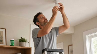 How to get more greens: a man changing a bulb in his hallway ceiling fitting