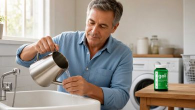 Spirulina benefits: a man descaling a kettle at a bright utility room sink